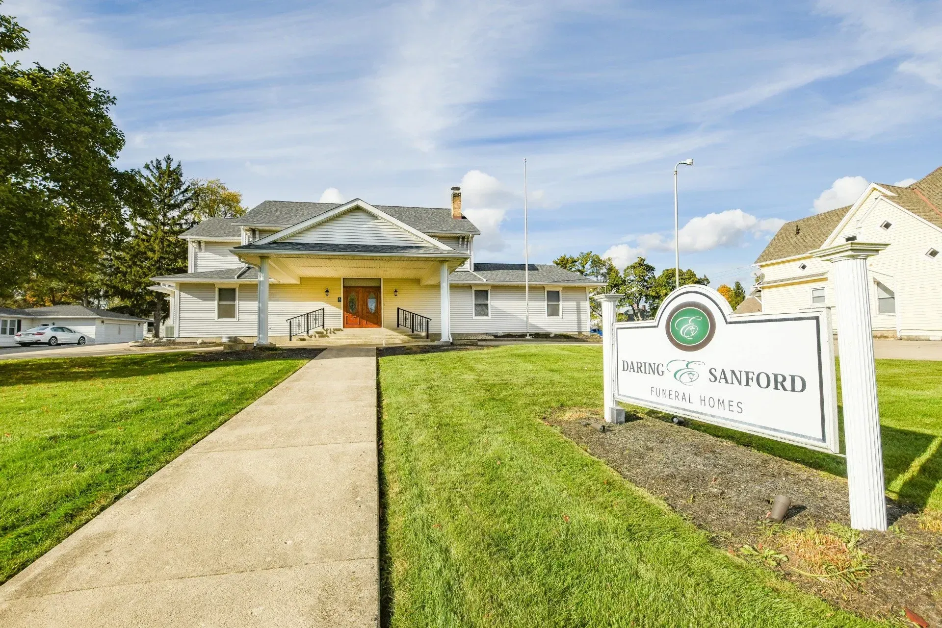 A white building with a sign in front of it.