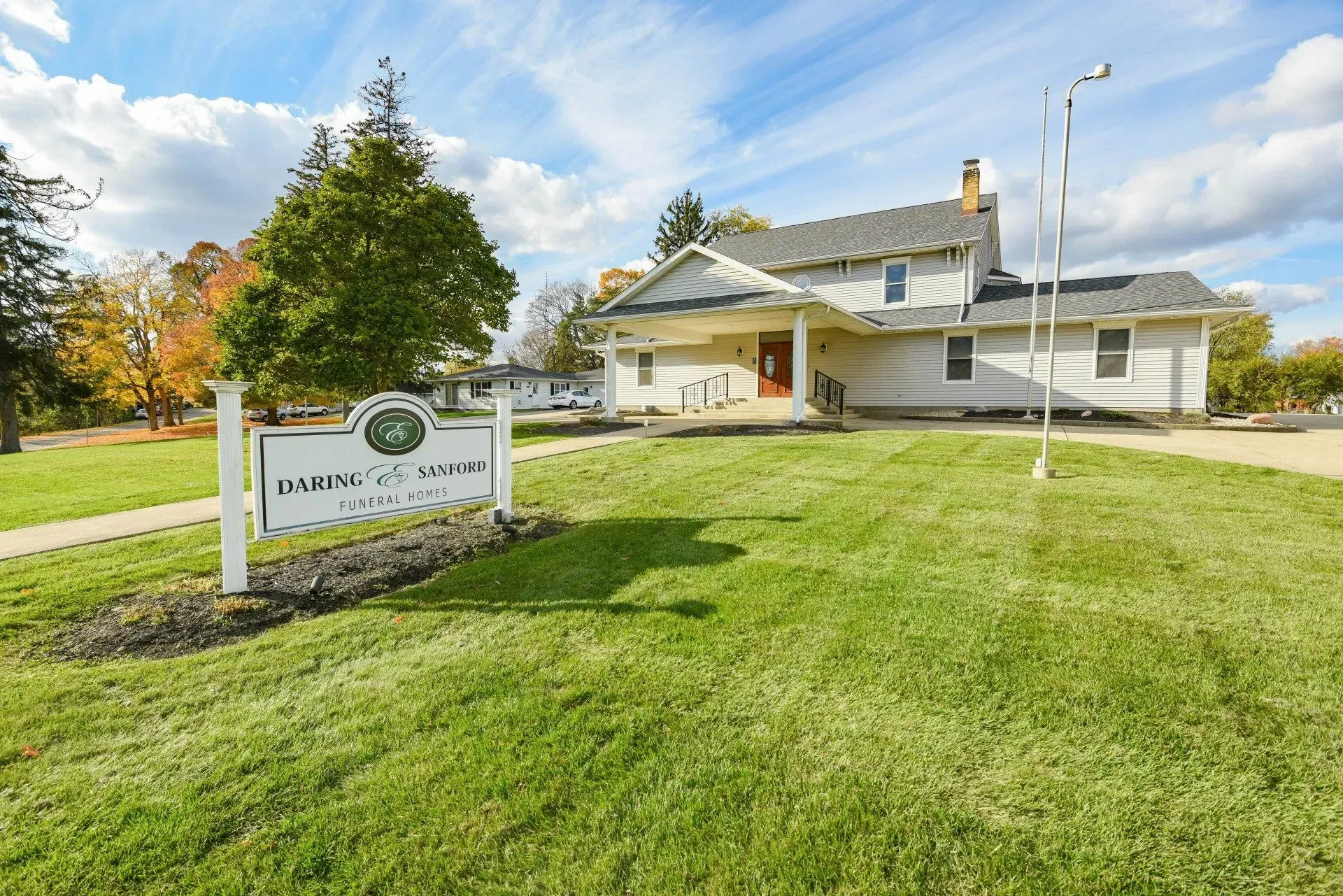 A large white house with a sign in front of it.