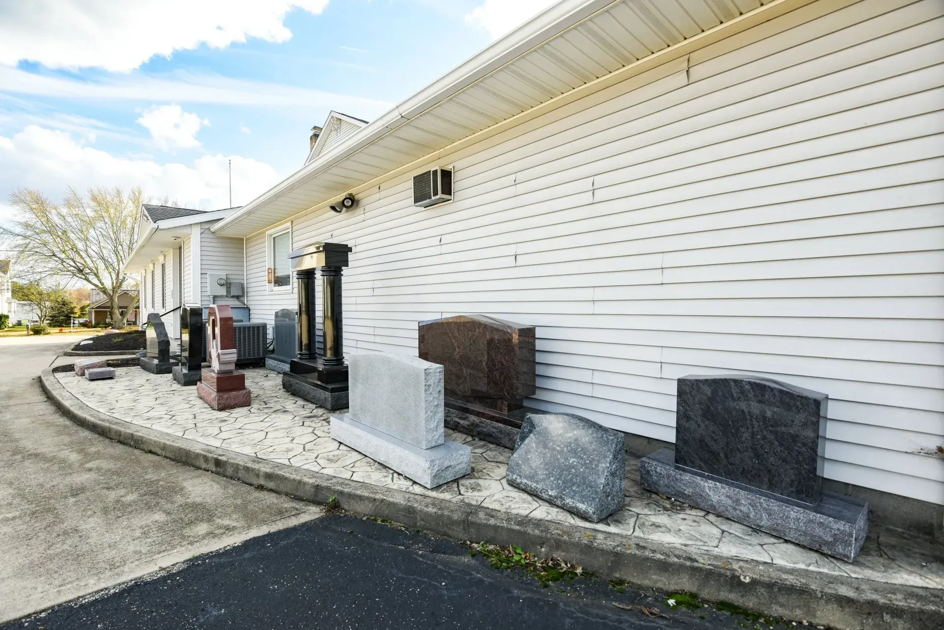 A white house with a lot of gravestones in front of it.