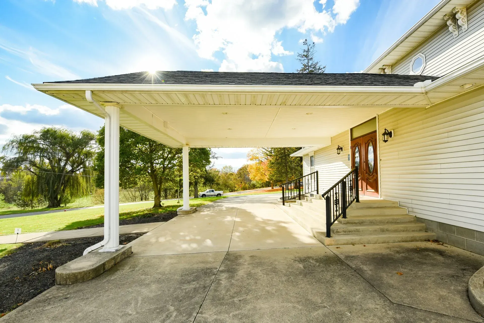 A white house with a porch and stairs leading to the front door.