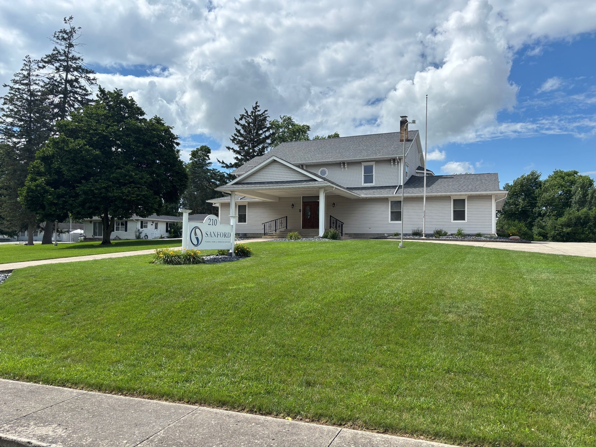 A large white house with a sign in front of it.