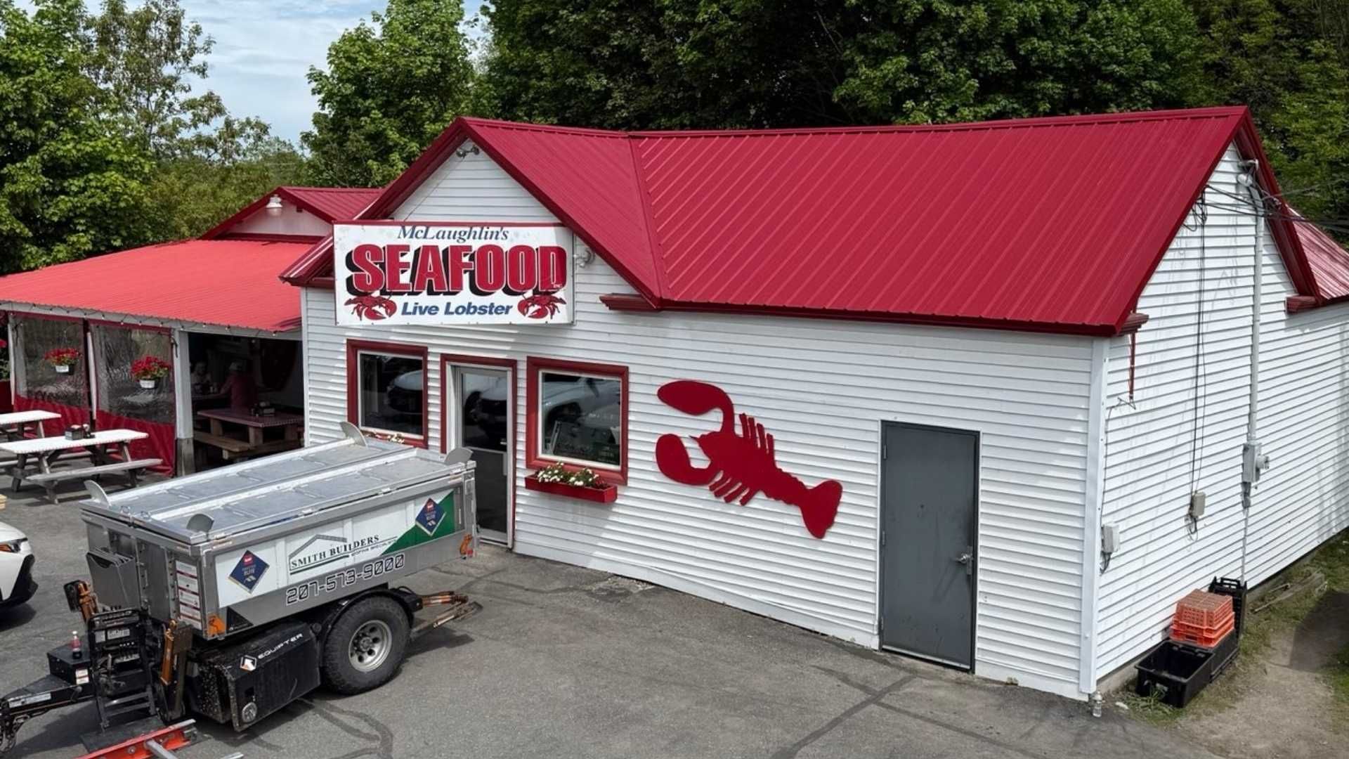 White seafood restaurant with red roof and a lobster sign.