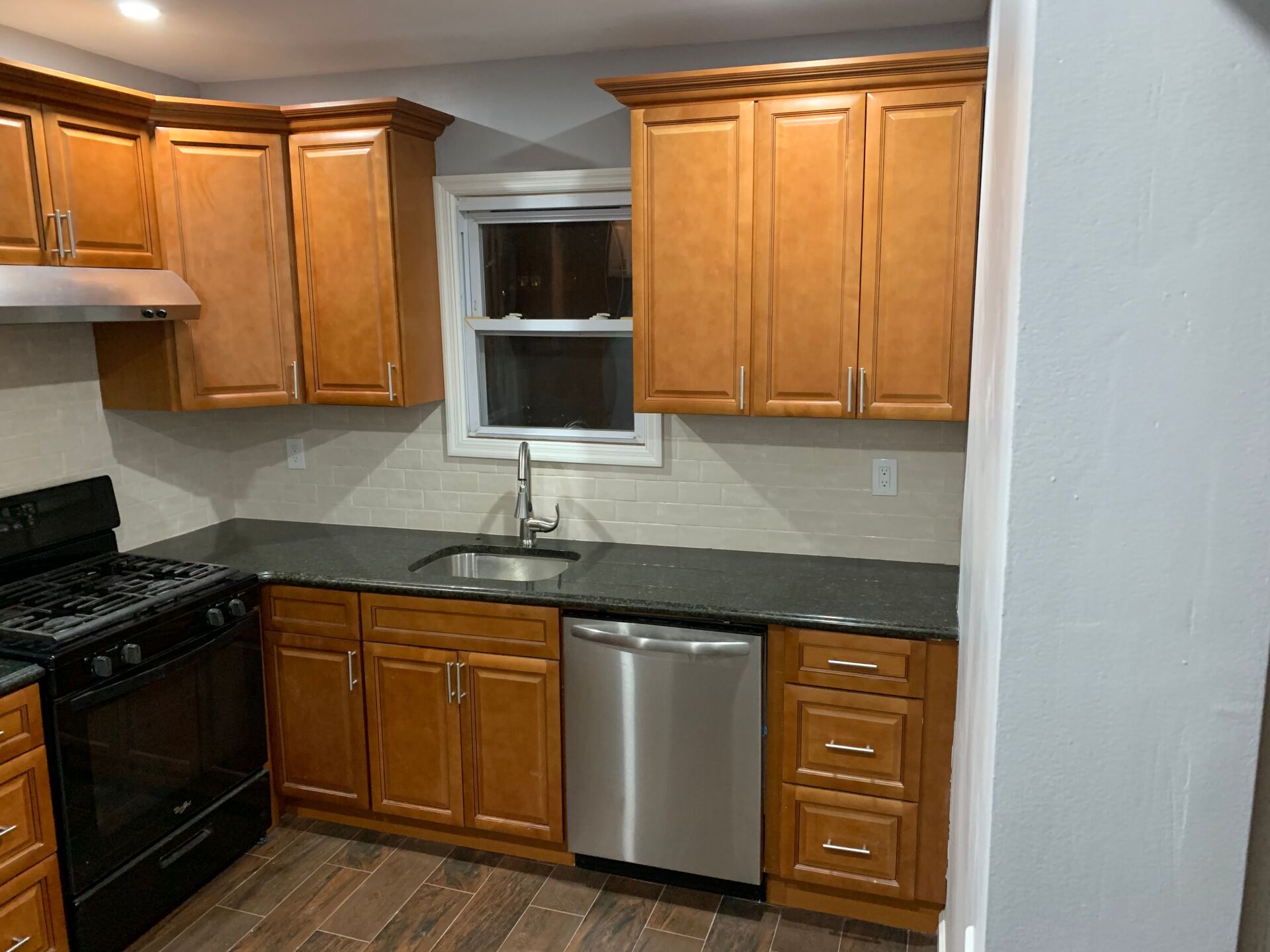 Kitchen with brown cabinets, dark countertops, and stainless steel appliances.