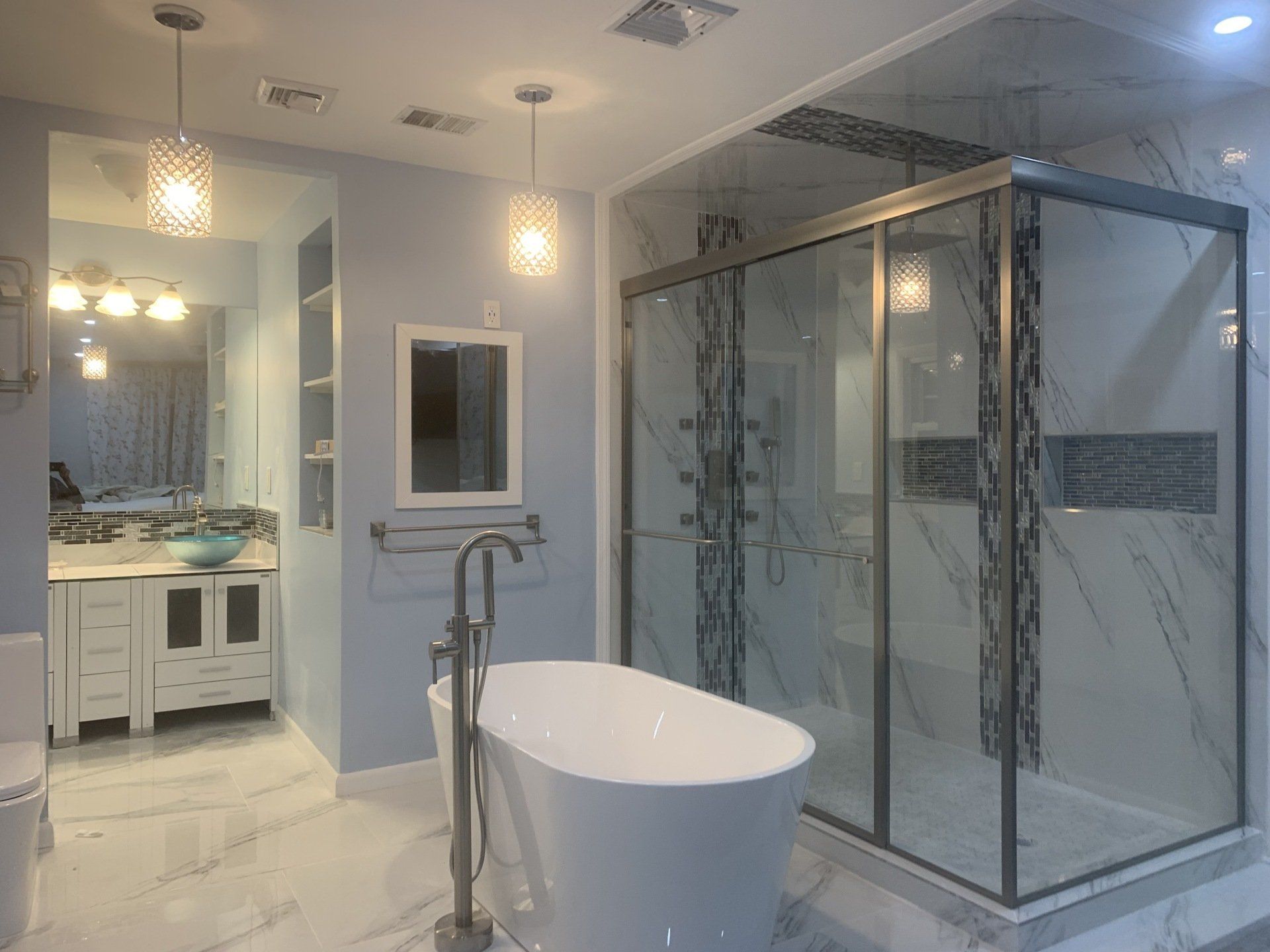 Luxurious bathroom with a freestanding tub, glass shower, and marble tile.