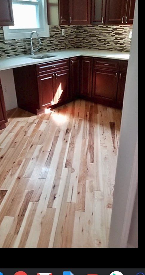 Kitchen with wooden cabinets, light wood floor, and backsplash.