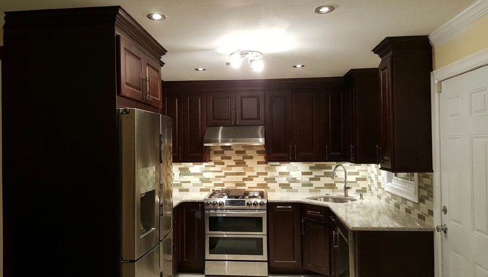 Dark brown kitchen cabinets and stainless steel appliances in a renovated kitchen.