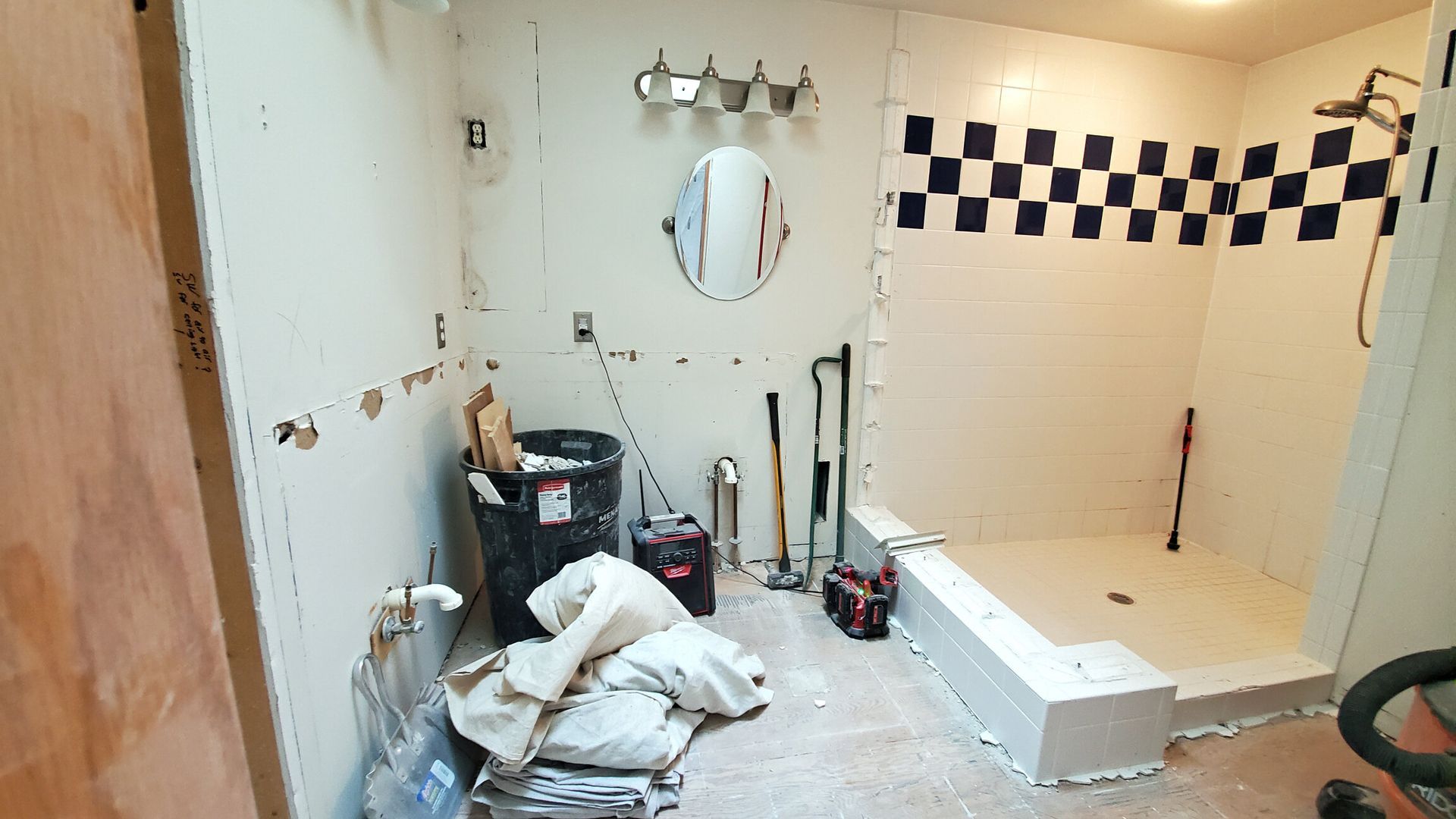 A bathroom that is being remodeled with a checkered wall