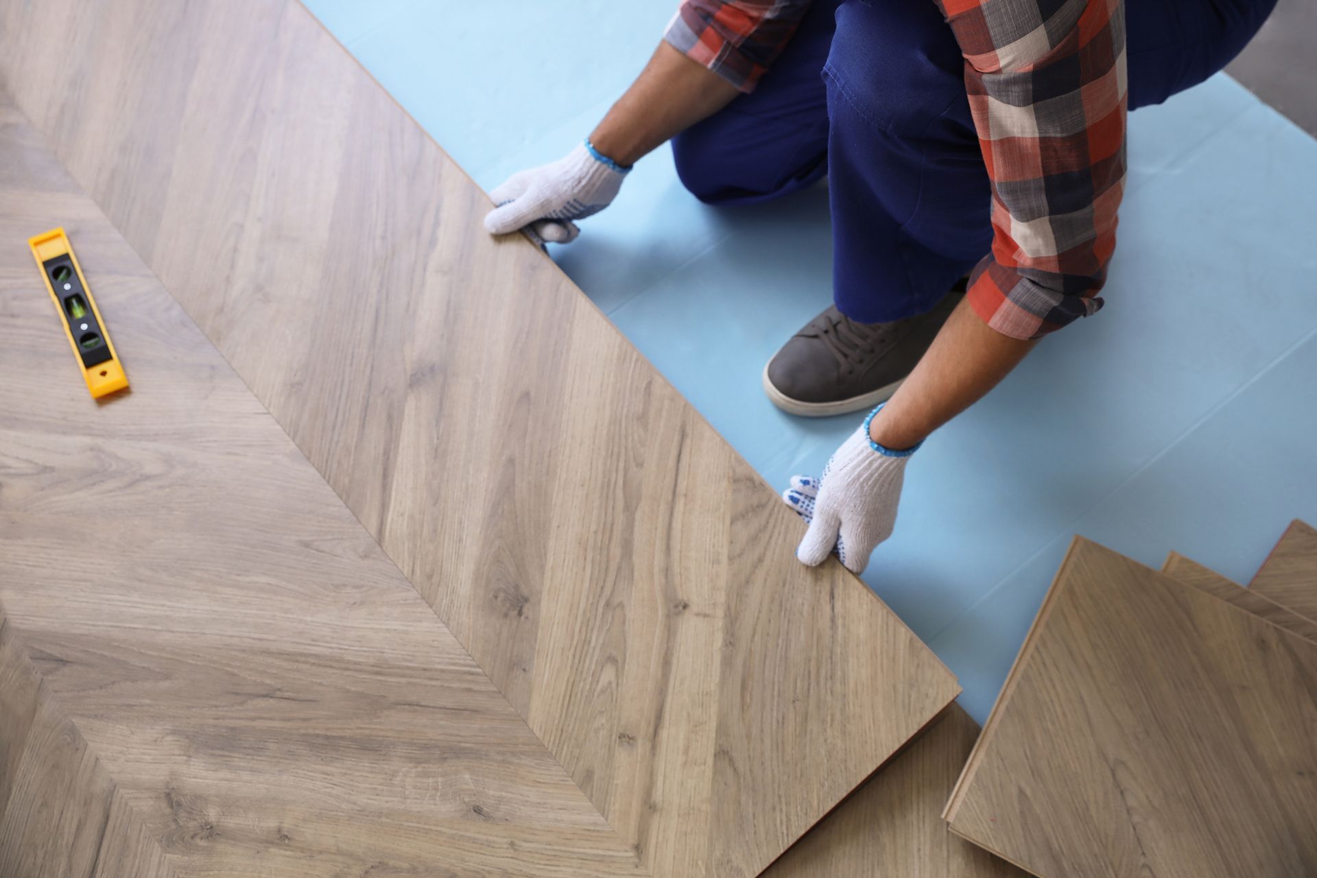 A person is installing a wooden floor in a room.