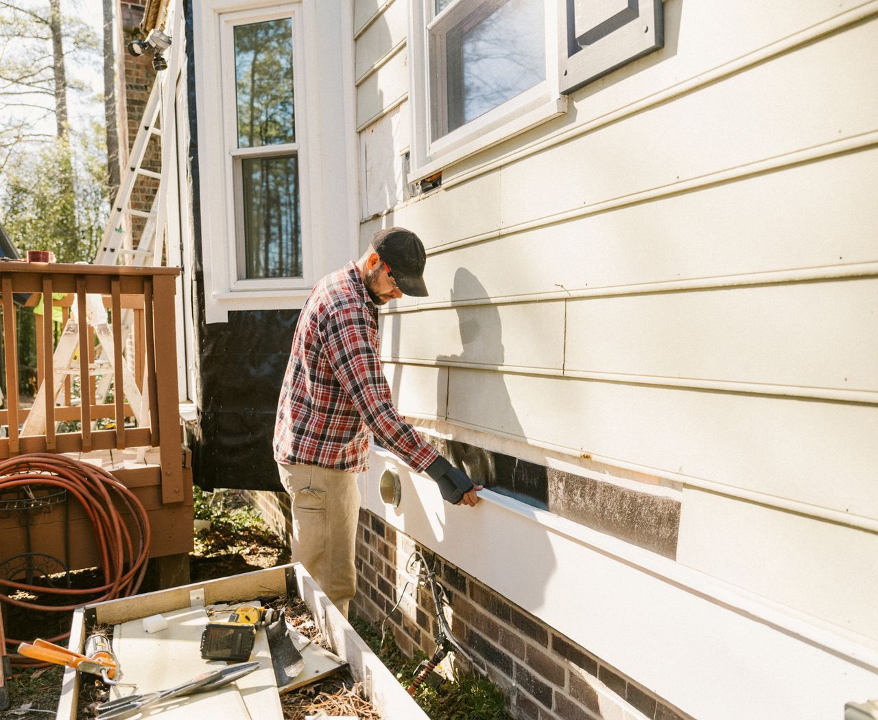 A man is working on the side of a house.