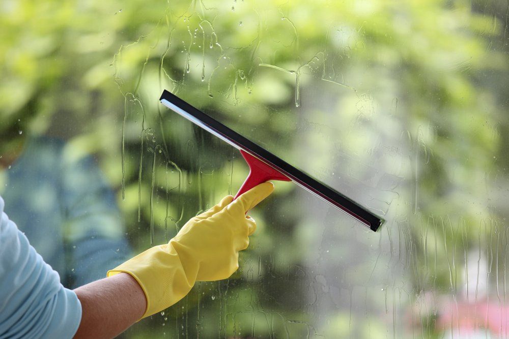 Removing the Water on Glass with a Squeegee — Highlands Window Cleaning in Mittagong, NSW