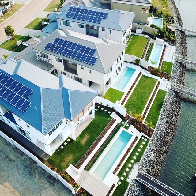 An aerial view of a house with solar panels on the roof
