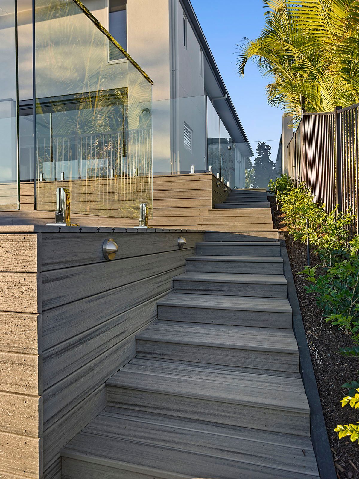 A set of stairs leading up to a house with a glass railing