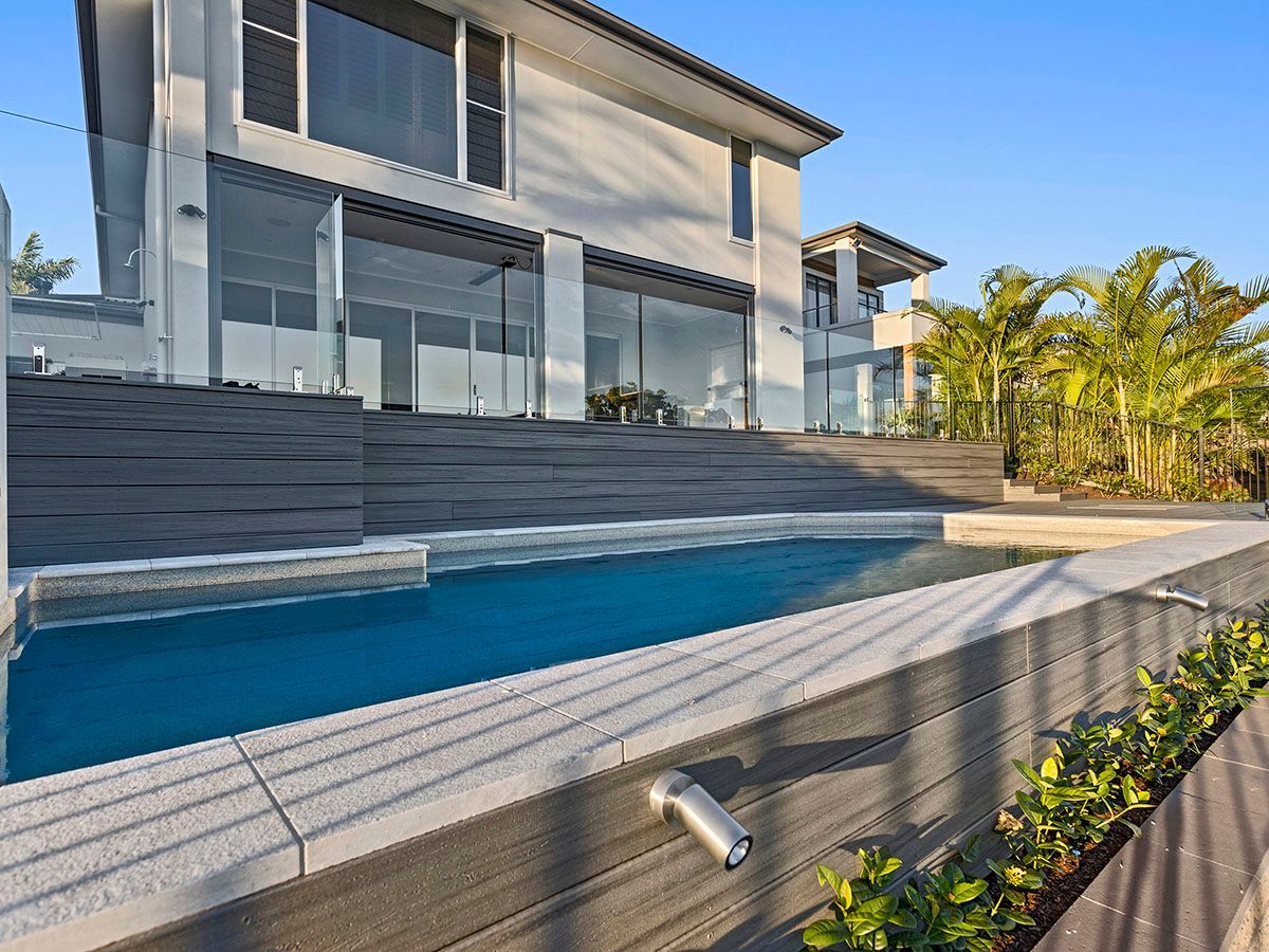 A large house with a swimming pool in front of it.