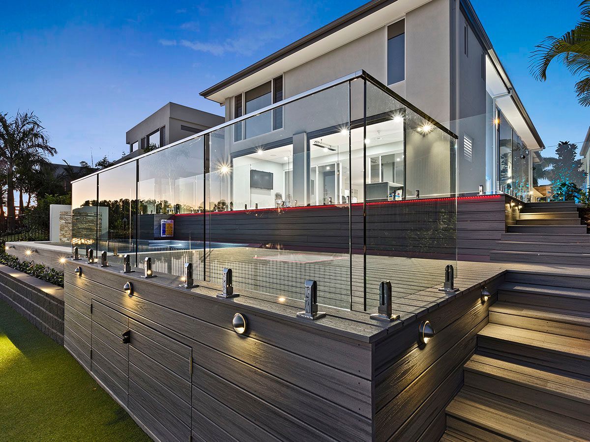 A large house with a glass railing and stairs leading up to it.
