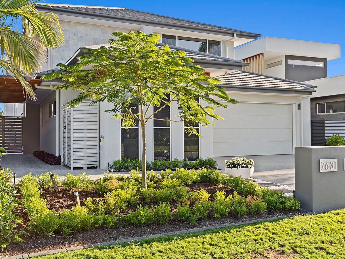 A large white house with a lush green lawn in front of it.