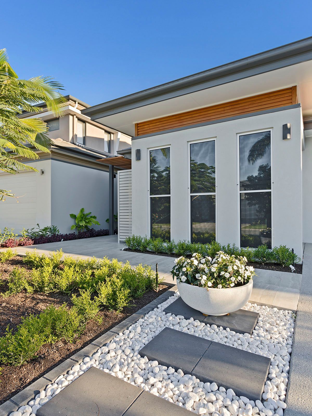 A white house with a bowl of flowers in front of it