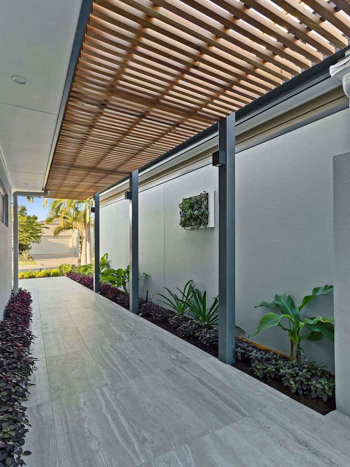 A walkway with a wooden pergola over it.