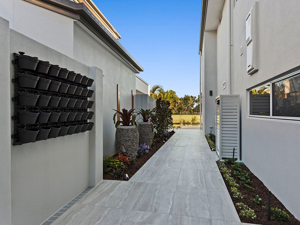 A walkway between two buildings with planters on the side