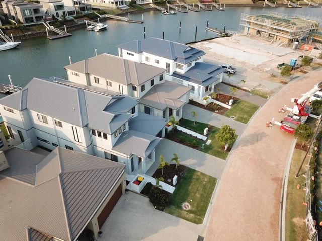 An aerial view of a row of houses next to a body of water.