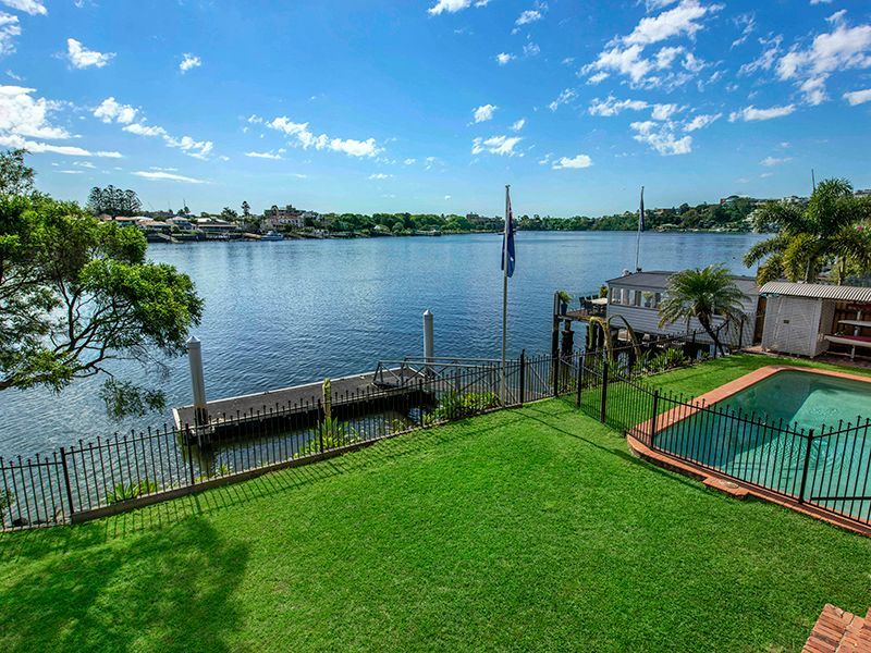 A large body of water with a dock and a swimming pool in the foreground.