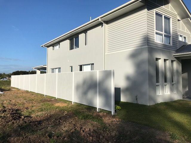 A large white house with a white fence in front of it.