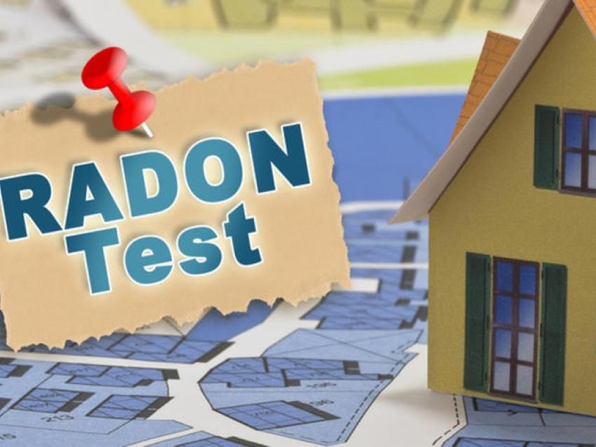 A small house model sits next to a note pinned to a blue floor plan, reading 