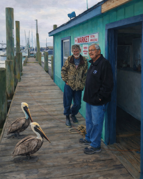 Two men stand near a turquoise market building on a wooden pier; two brown pelicans are nearby.