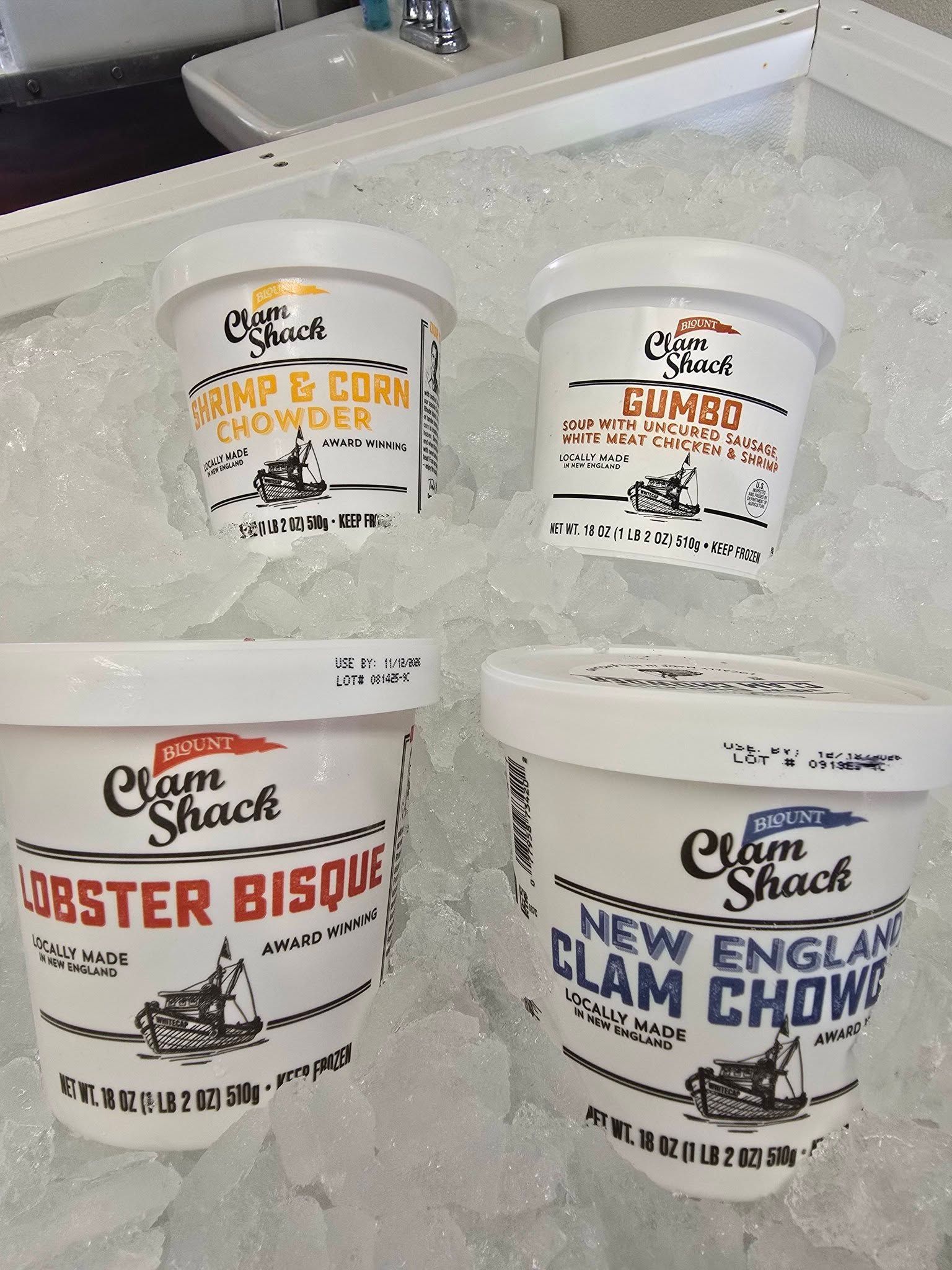 Four white cups of soup on ice: Shrimp & Corn Chowder, Gumbo, Lobster Bisque, and New England Clam Chowder.