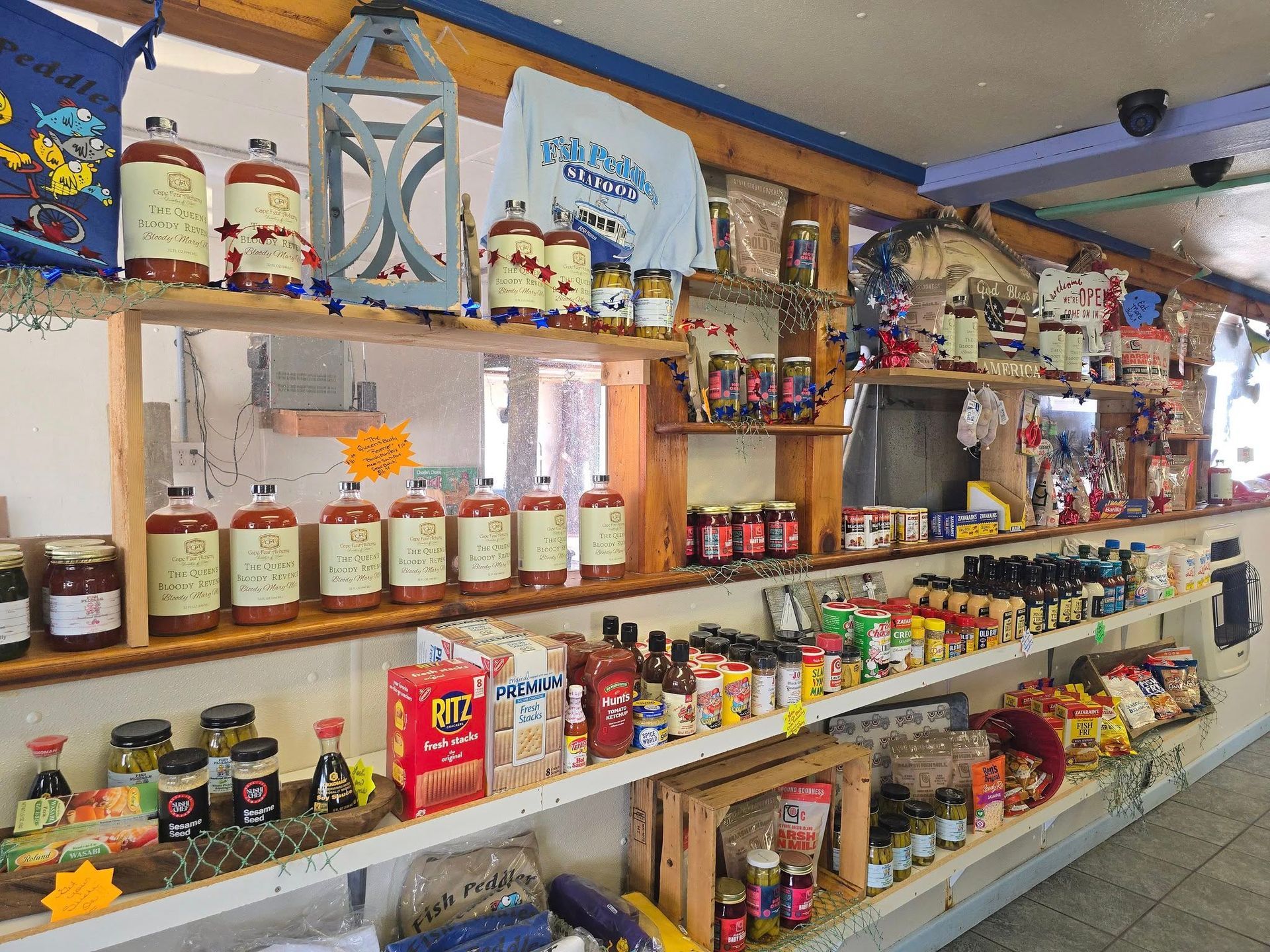 Shelves of food products in a store, including sauces and packaged goods. Wooden shelving, natural light.
