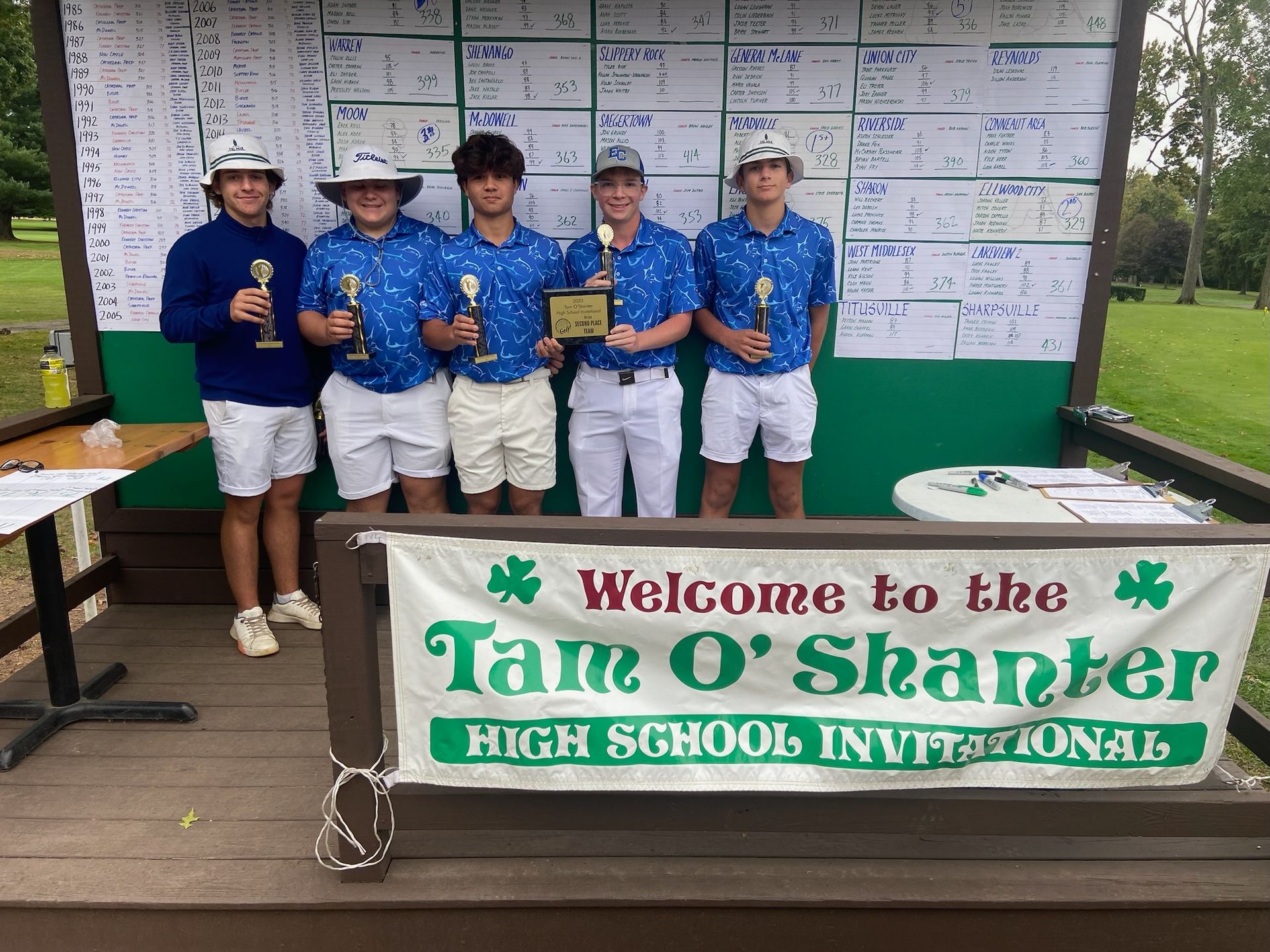 High school golfers holding trophies and plaque at the 