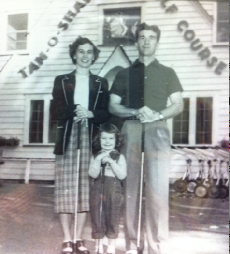 Family posing with golf clubs in front of a golf course building.