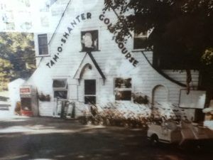Tam O'Shanter Golf Course building with signage. A small car is parked in front.