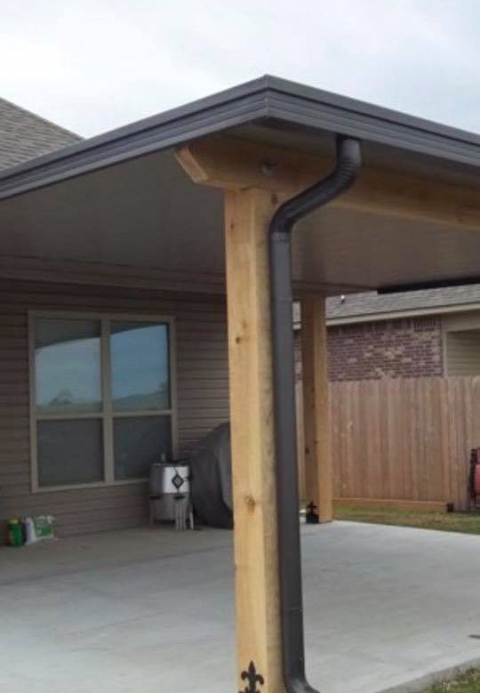 Patio roof with dark gutters and wooden support columns.