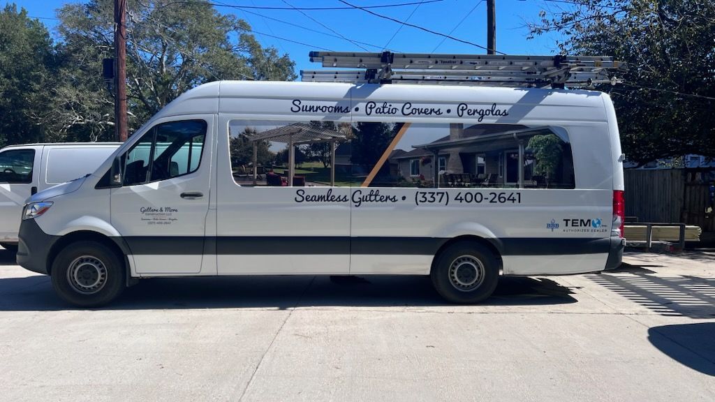 White van with ladder on top, text reads 