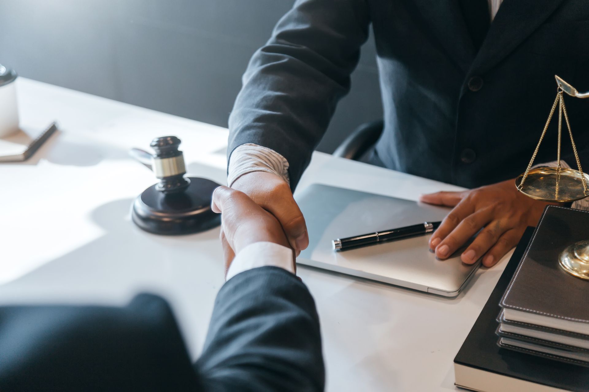 A drug criminal defense attorney is shaking hands with their client at his office. A drug criminal defense attorney is shaking hands with their client at his office.