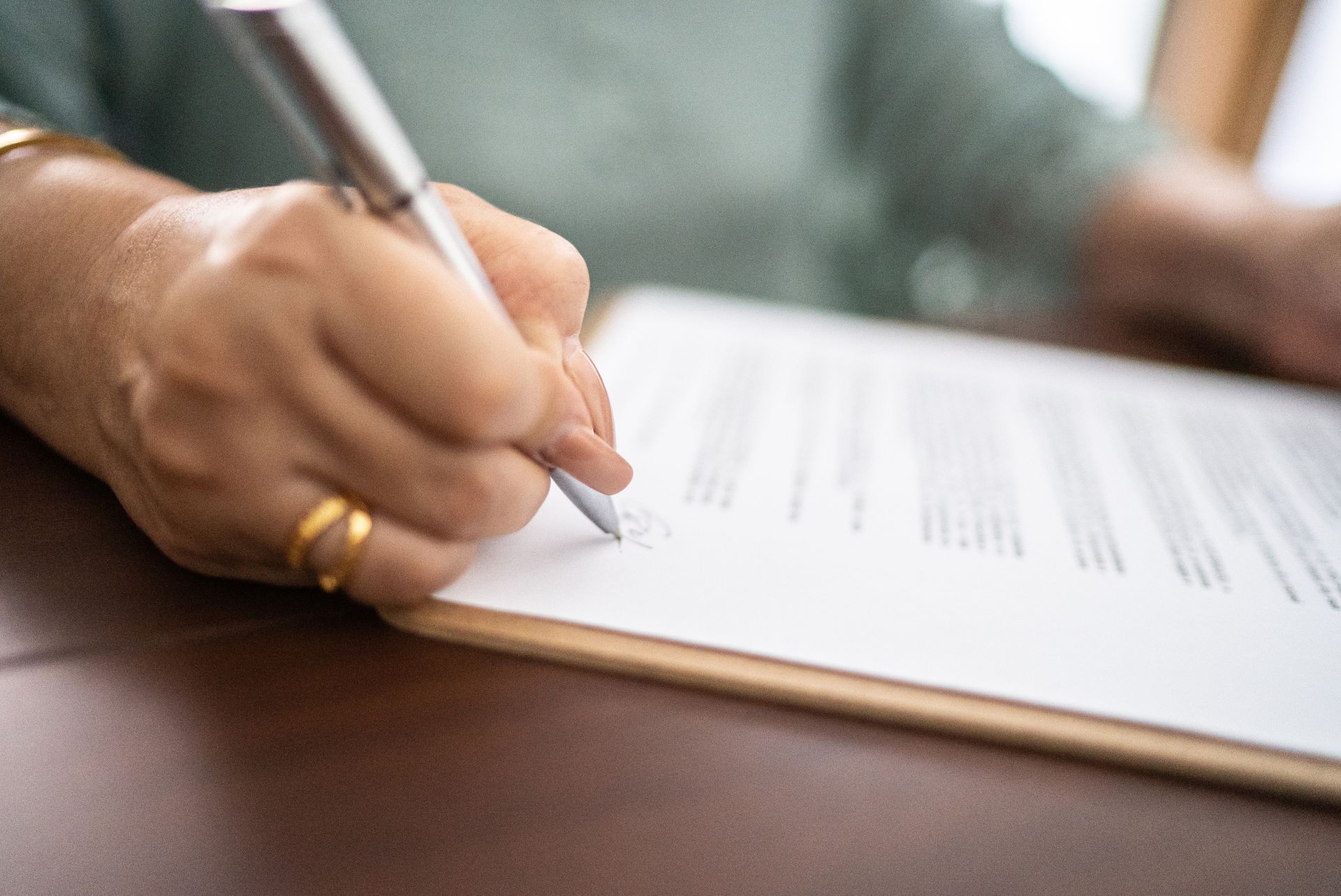 A woman is signing a document.