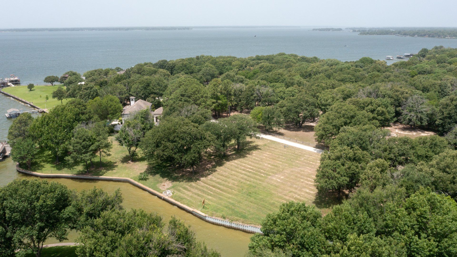 A large body of water surrounded by trees and grass