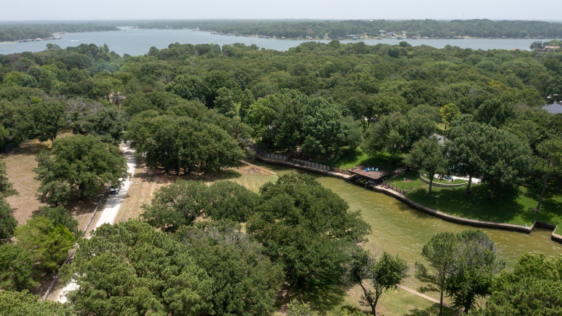 An aerial view of a park with trees and a lake in the background