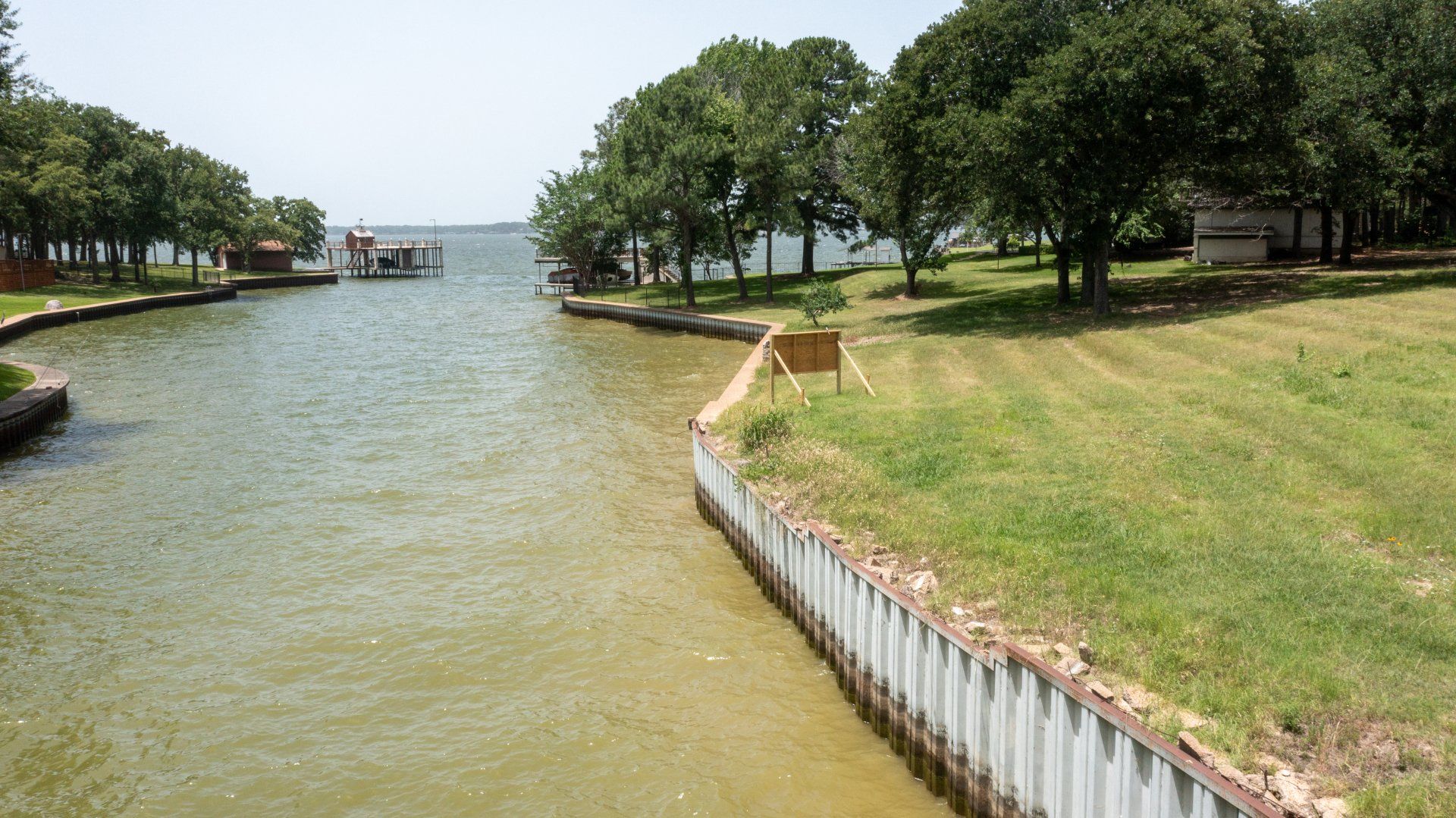 A large body of water surrounded by trees and grass