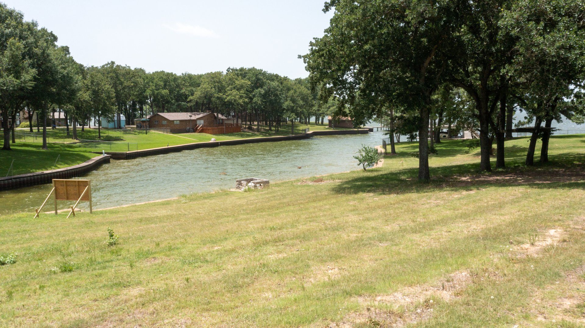 A large body of water surrounded by trees and grass