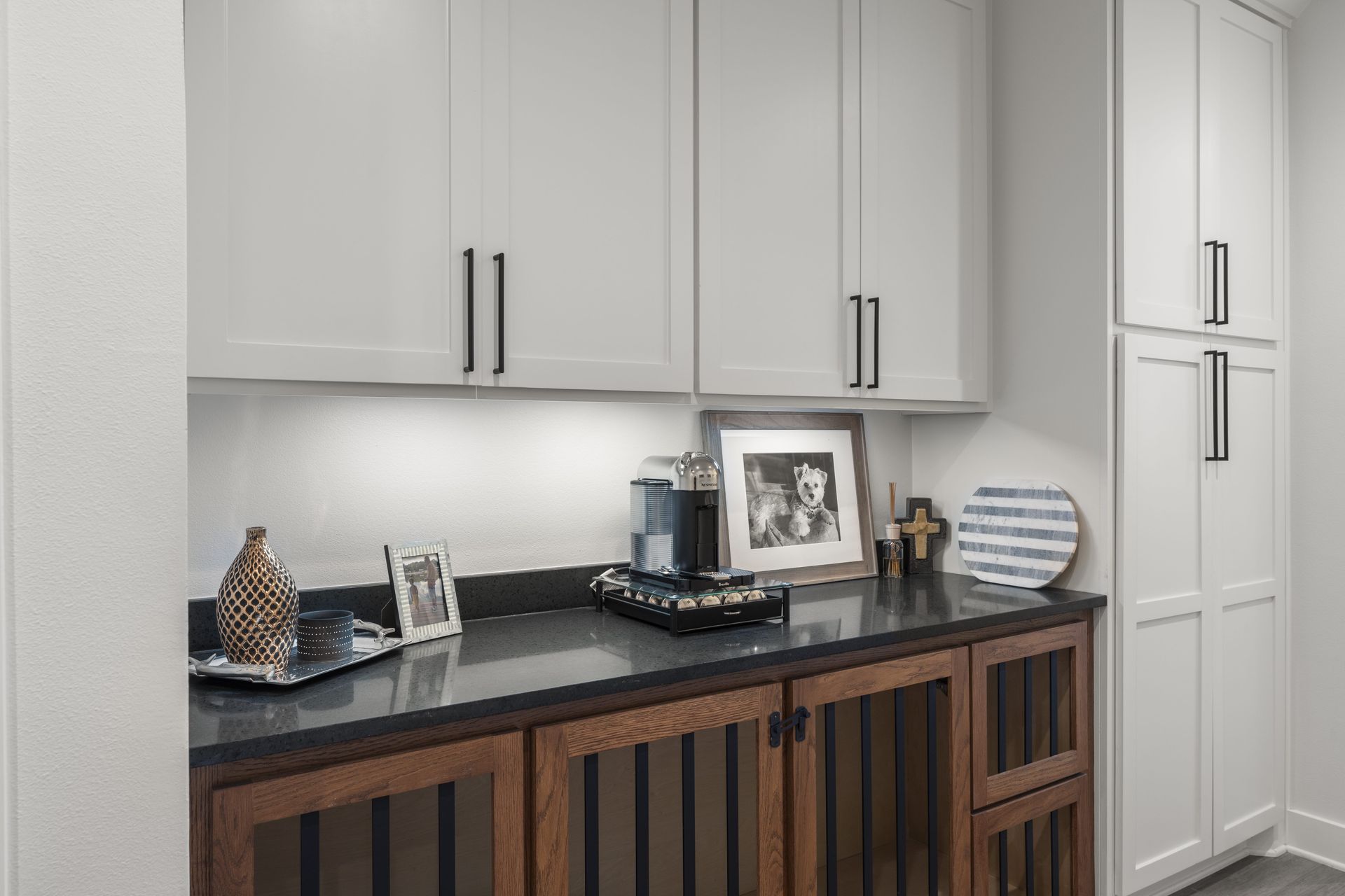 A kitchen with white cabinets and wooden cabinets and a counter top.