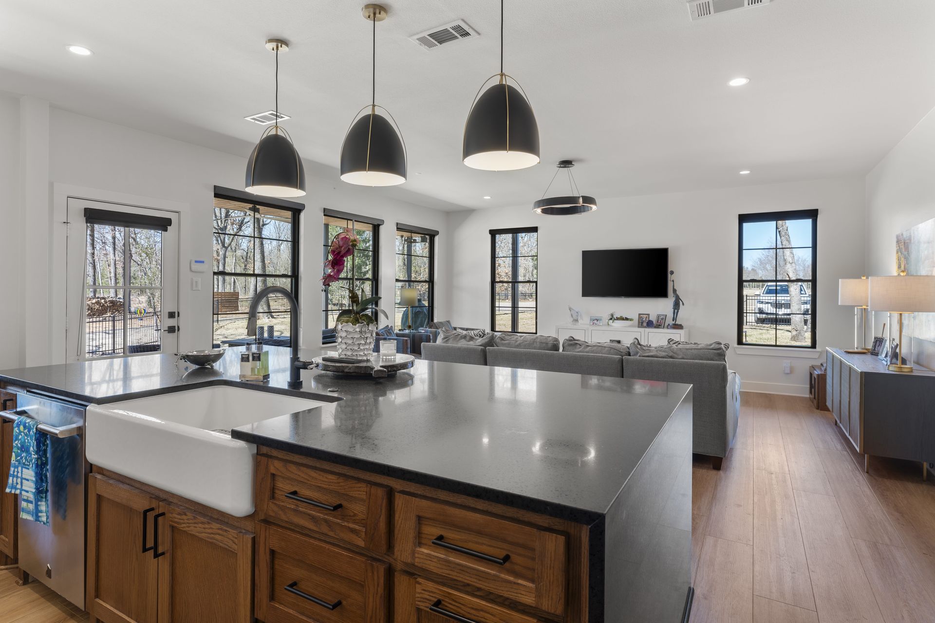 A kitchen with a large island , a sink , and a flat screen tv.