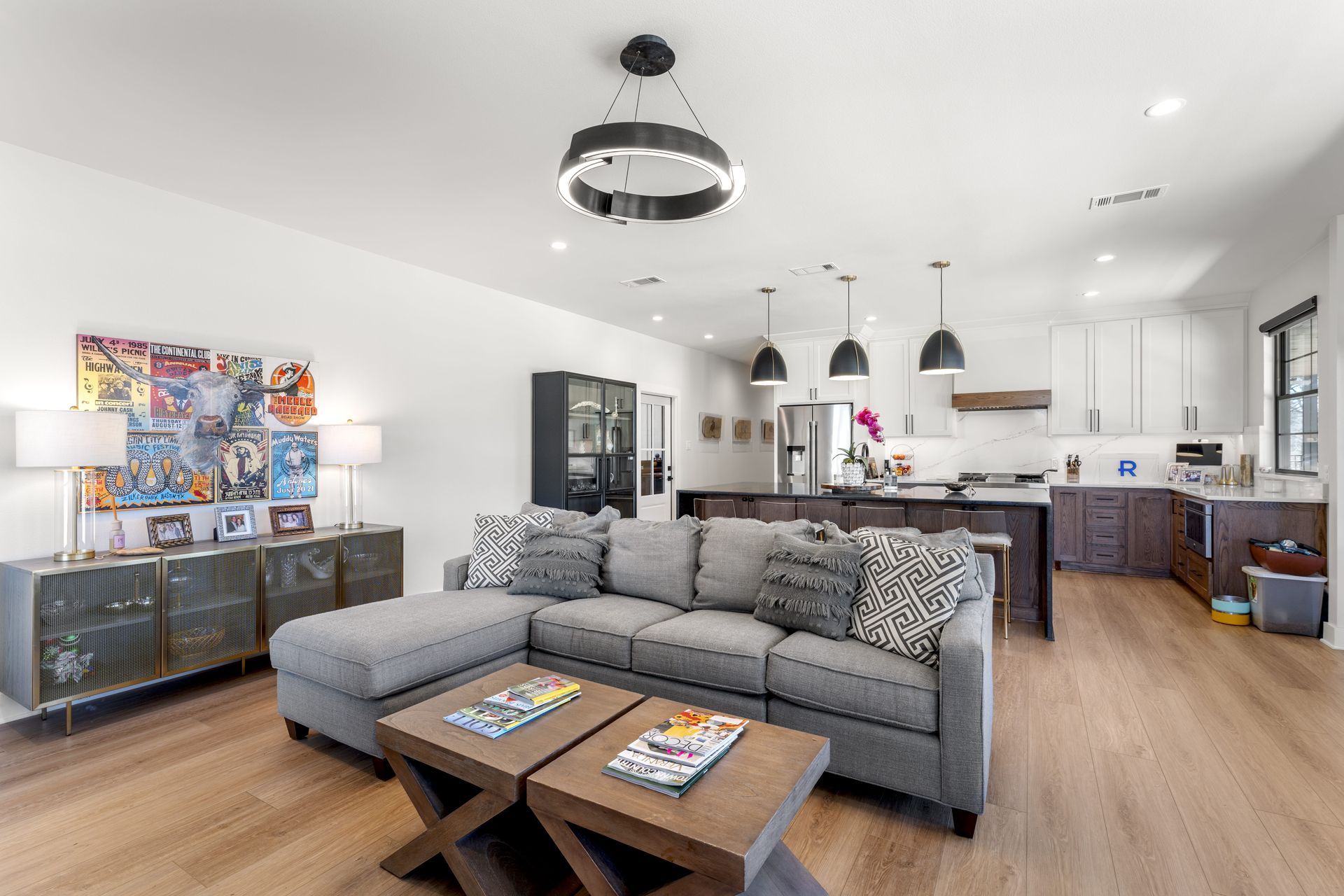 A living room with a couch , coffee tables , and a kitchen.