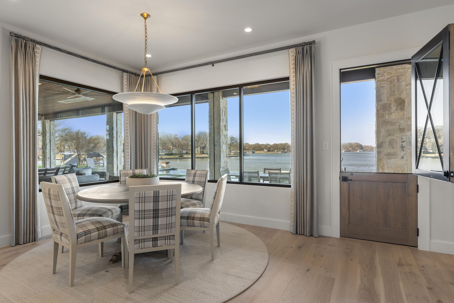 A dining room with a table and chairs and a view of a lake.