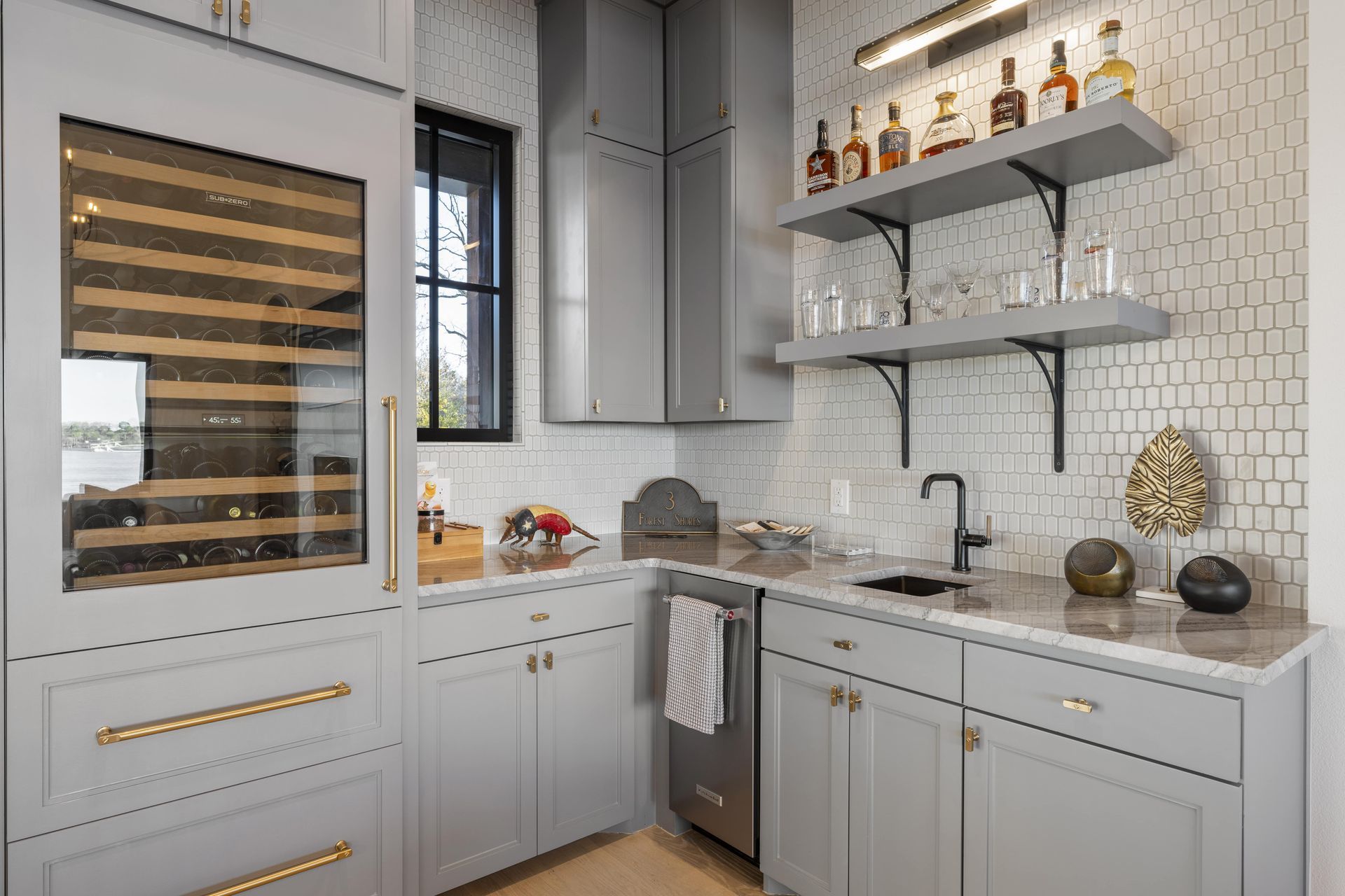 A kitchen with a wine cooler , sink , and shelves.