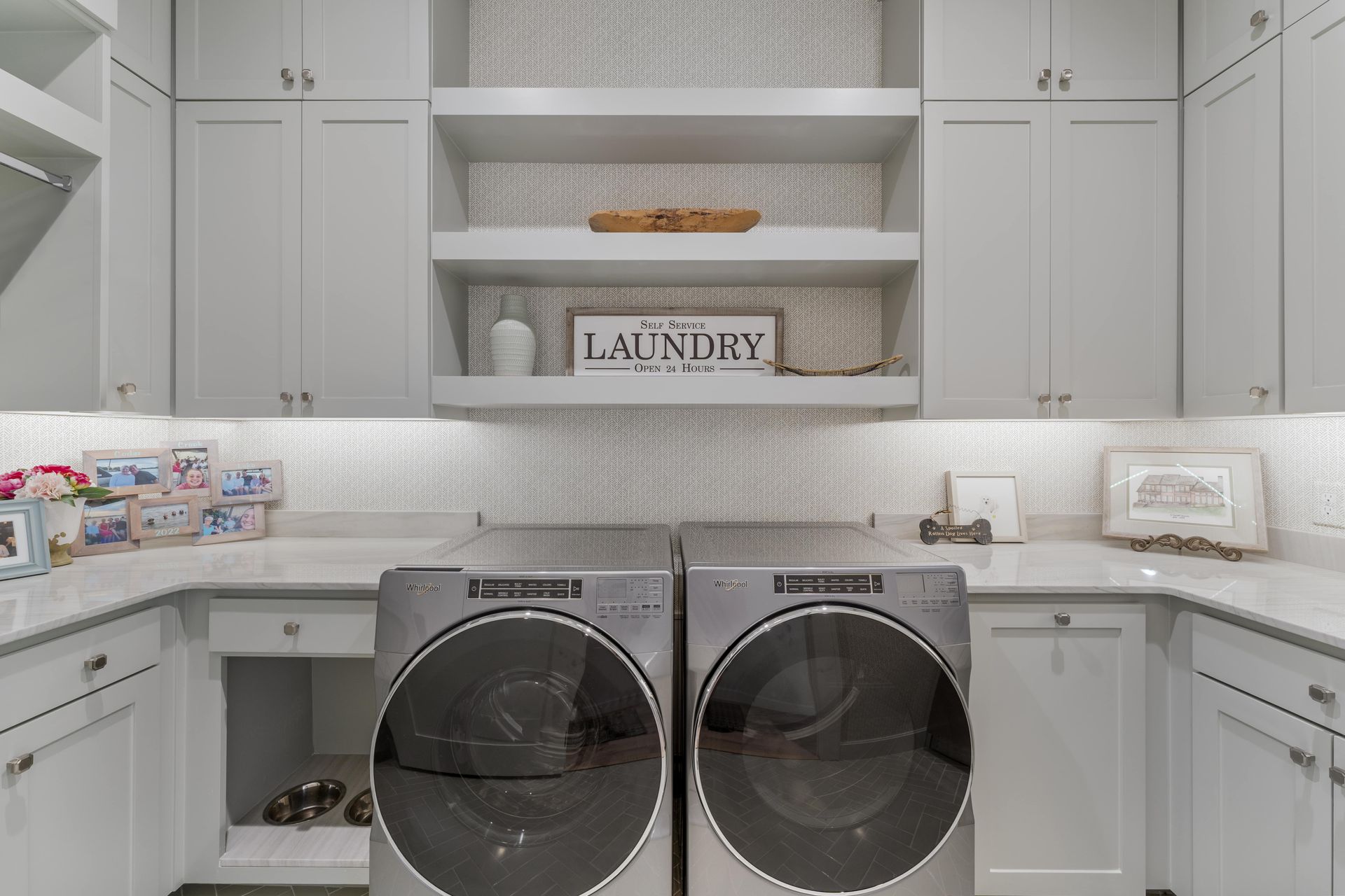 A laundry room with a washer and dryer and white cabinets.
