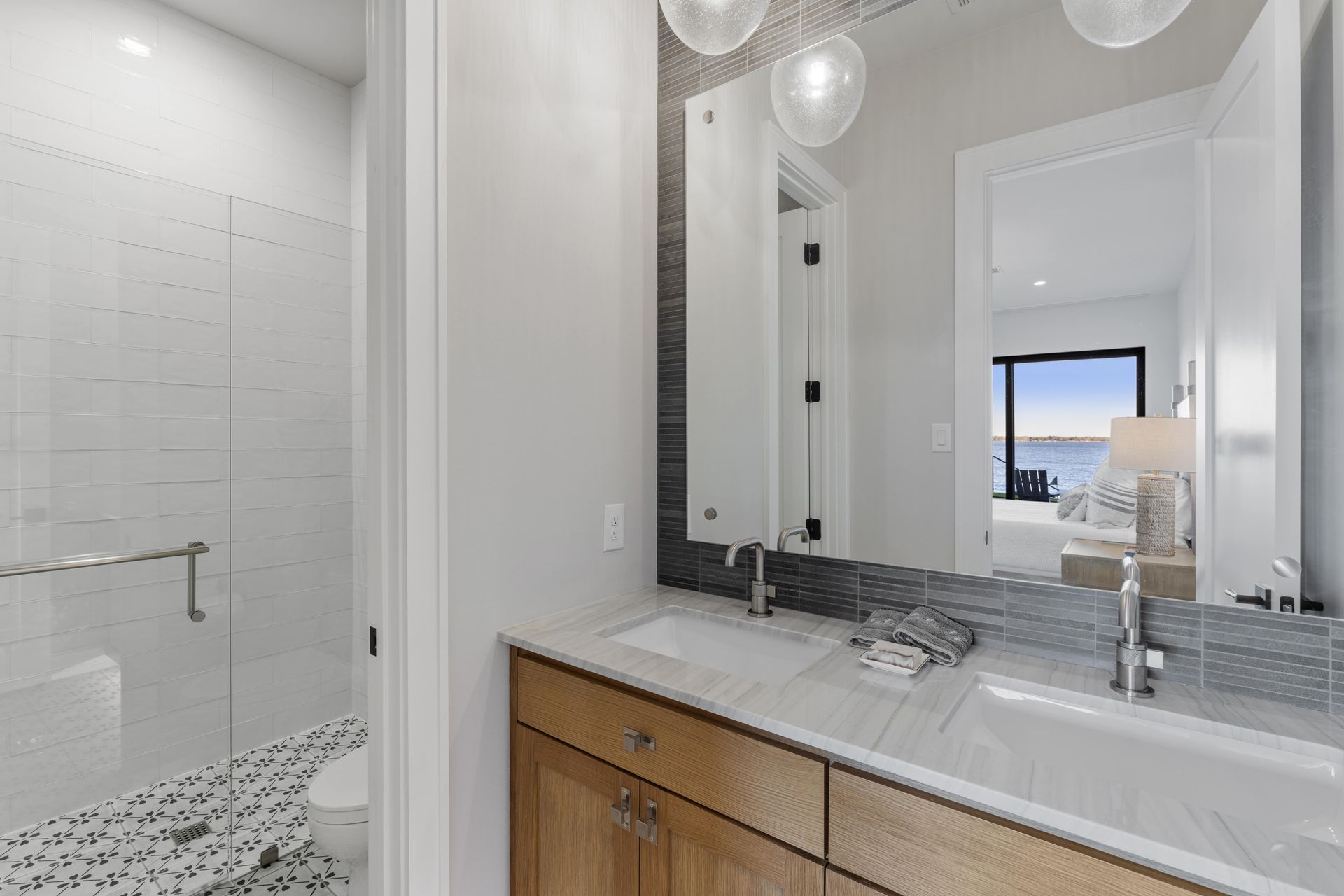A bathroom with a sink , mirror and walk in shower.