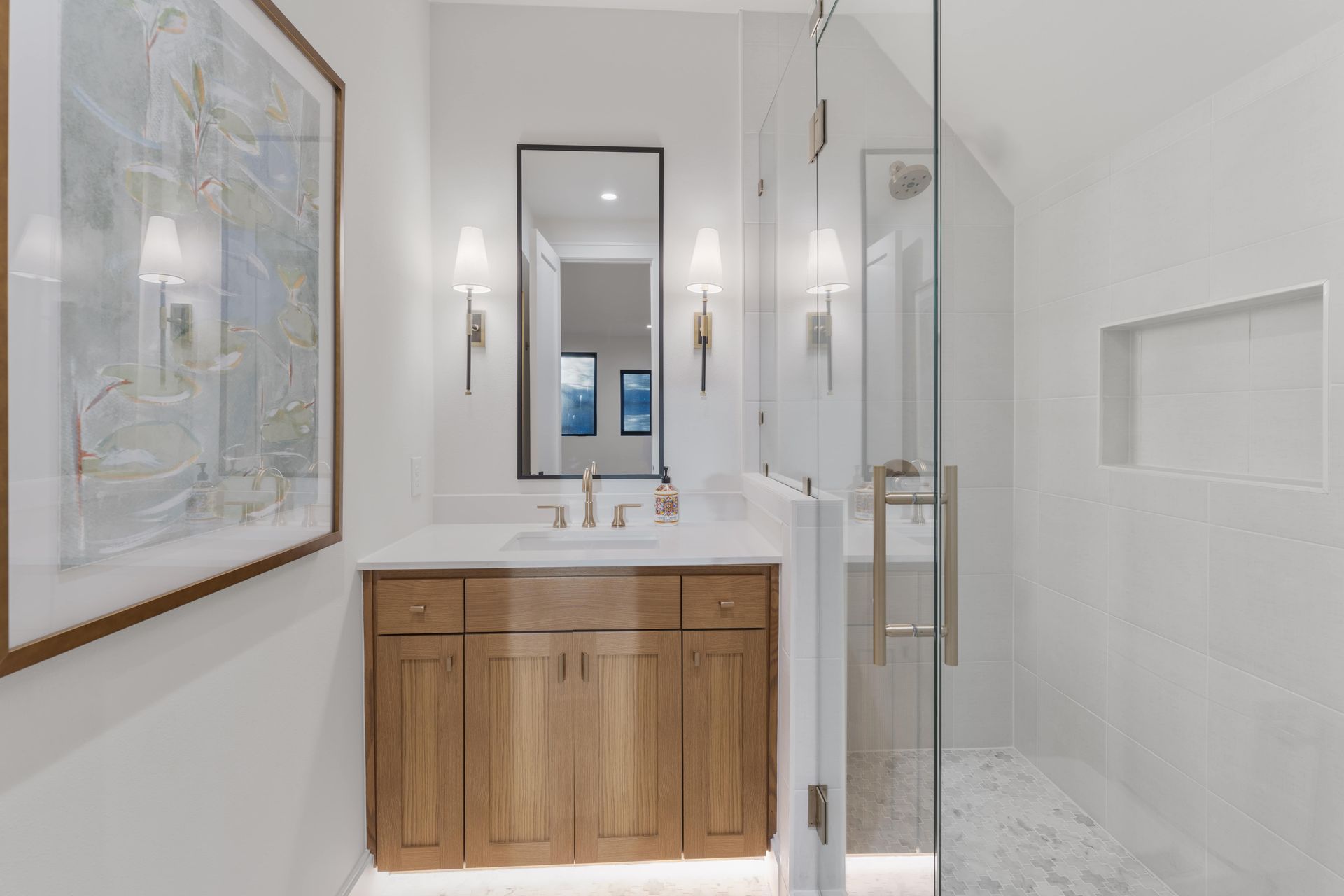 A bathroom with a sink , mirror , and walk in shower.
