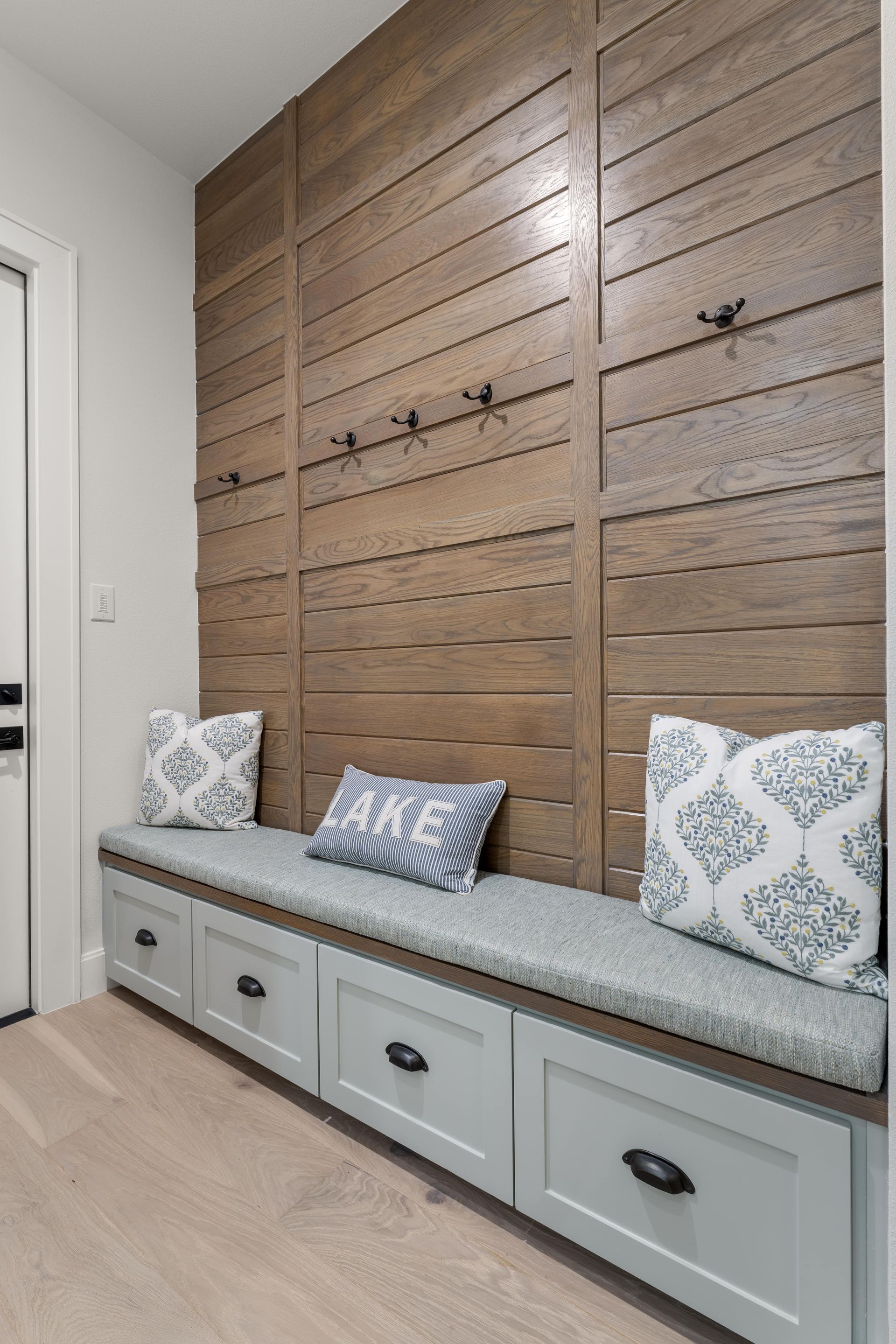 There is a bench with drawers underneath it in the hallway.