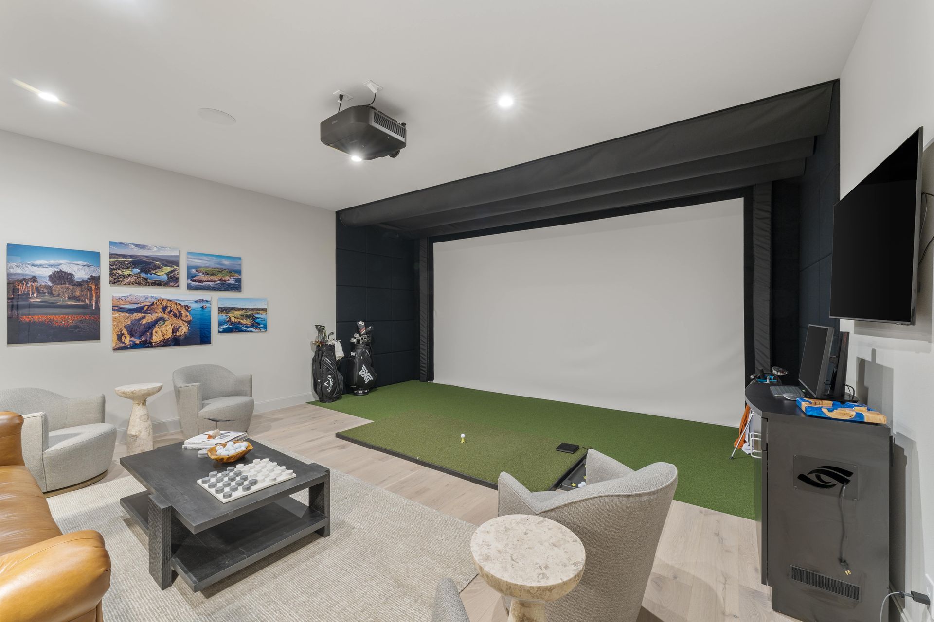A living room with a projector screen and a golf course.